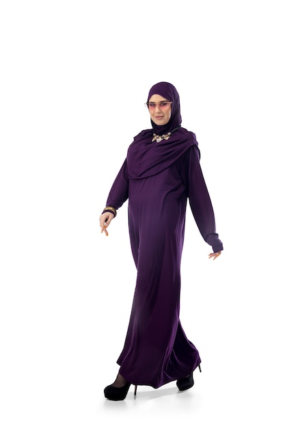 Sério. Linda mulher árabe posando em um elegante hijab em fundo de estúdio com copyspace para anúncio. Moda, beleza, conceito de estilo. Modelo feminino com maquiagem da moda, manicure e acessórios.