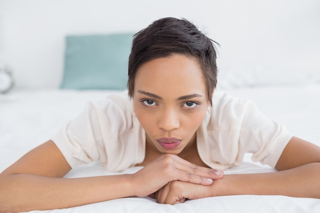 Sério, mulher bonita, relaxante na cama