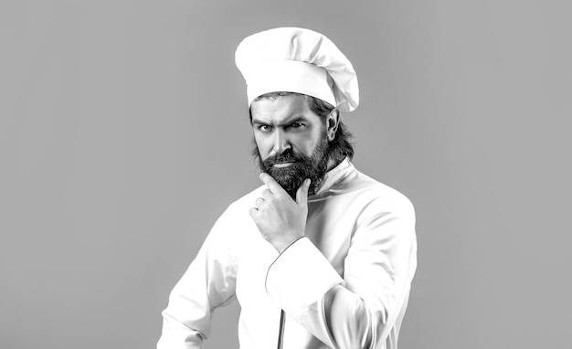 Seriöser Koch in weißer Uniform Kochmütze Porträt eines seriösen Chefkochs Bärtige Chefköche oder Bäcker Bärtige männliche Köche isoliert Kochmütze