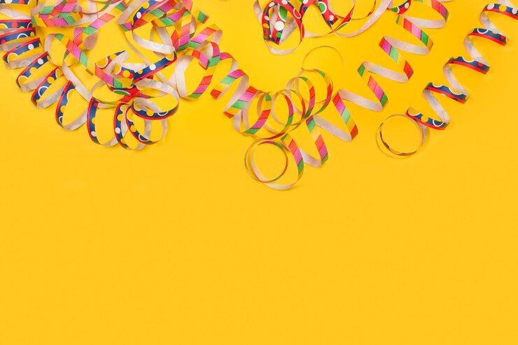 Foto serpentinas de papel colorido em um fundo amarelo com espaço de cópia