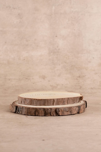 Serra redonda de madeira cortada em forma de cilindro para apresentação do produto em um fundo bege