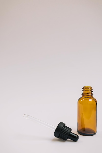 Serum oder ätherisches Öl in brauner Glasflasche mit Pipette und auf weißgrauem Hintergrund Minimales DIY-Naturkosmetikkonzept Gesichtspflege Null-Abfall-Produkt Mock-up mit Kopierraum