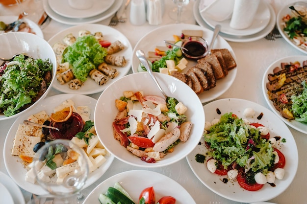 Serve o jantar em uma mesa festiva Comida Saladas Carne Peixe Refeições Mesa festiva no banquete de casamento Detalhes da decoração Vista superior