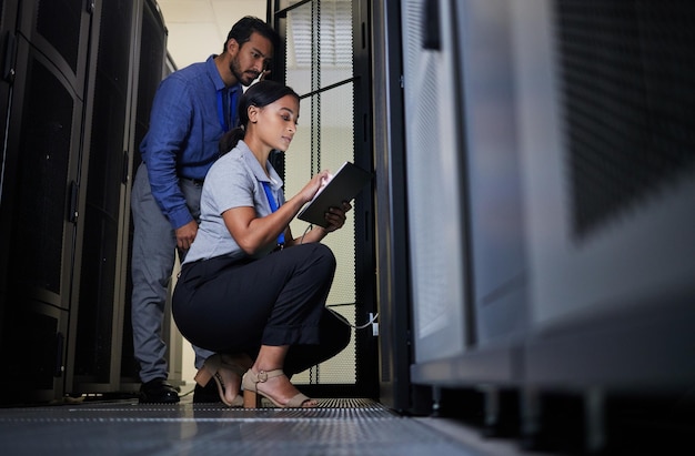 Serverraumingenieur und Team mit Tablet für Datenbankverbindungskabelwartung oder Softwareupdate in der Nacht Cybersecurity it und Mann und Frau mit Technologie für die Vernetzung im Rechenzentrum