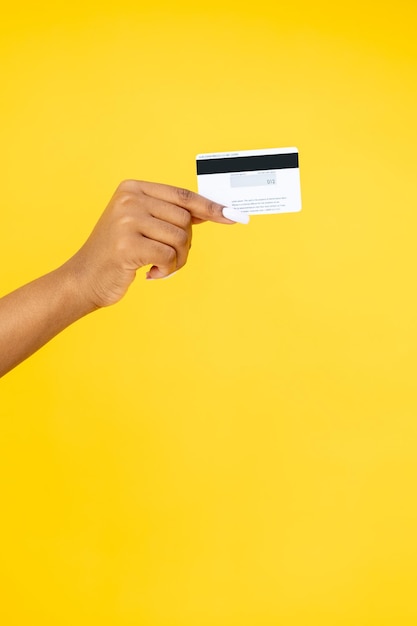 Foto servicio bancario transferencia de dinero compras en línea primer plano de una mano de mujer sosteniendo una tarjeta de crédito aislada en el fondo del espacio de copia naranja