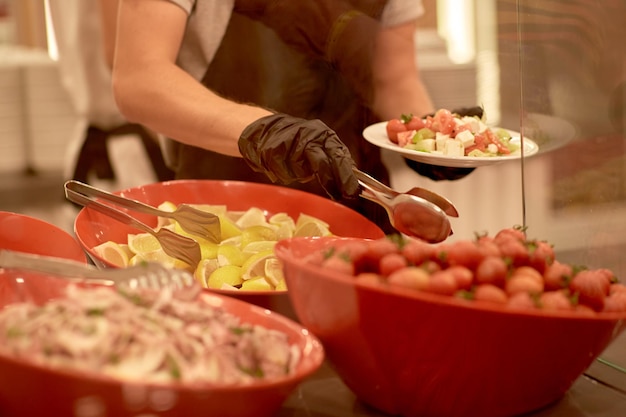 Servicio de catering buffet de distribución de alimentos La persona está sirviendo comida