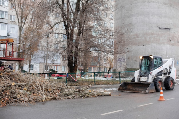 El servicio de emergencia urbano elimina un árbol caído en una carretera con un equipo especial traktor.