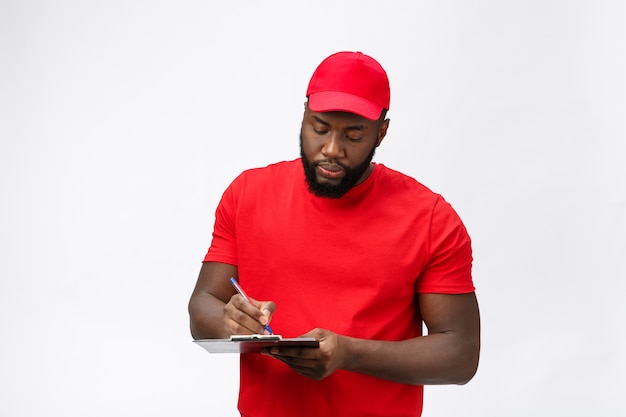 Servicio de entrega - Retrato de apuesto hombre de entrega afroamericano o mensajero que muestra un formulario de documento de confirmación para firmar.