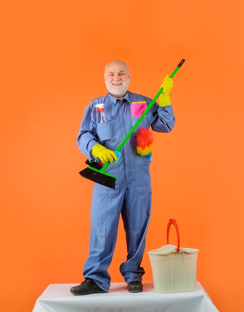 Servicio de limpieza anciano en uniforme con equipo de limpieza servicio doméstico limpieza profesional