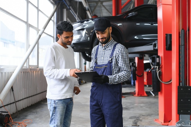 Foto servicio mecánico de automóviles en el concepto de garaje de mantenimiento oportuno del automóvil de servicio al cliente y acuerdo de trato