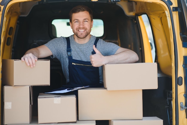 Servicio de mensajería para la entrega de mercancías Servicio exprés un hombre uniformado entrega cajas El empleado lleva el pedido a casa del cliente