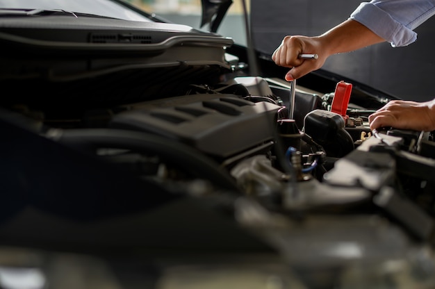 Servicio de reparación de automóviles. Auto mecánico trabajando en garaje.