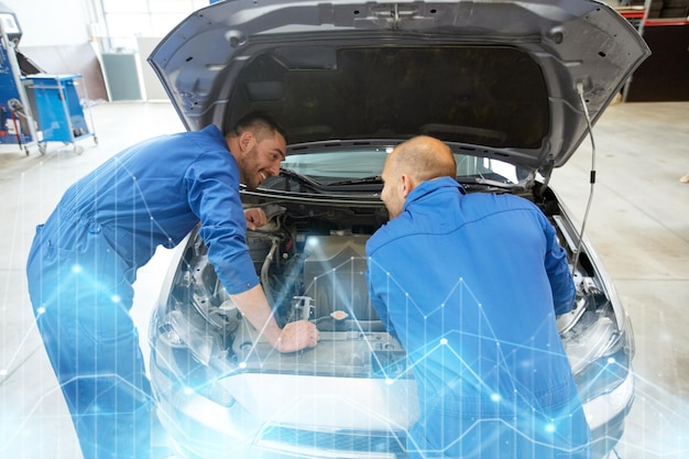 servicio de reparación de automóviles mantenimiento y concepto de personas mecánico hombres con llave inglesa reparación de automóviles en el taller