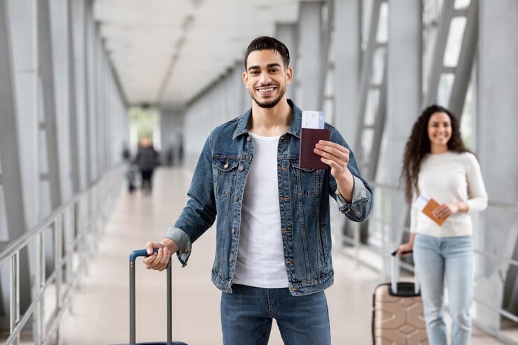 Servicio de reserva de vuelos hombre árabe posando con pasaporte y boletos en el aeropuerto