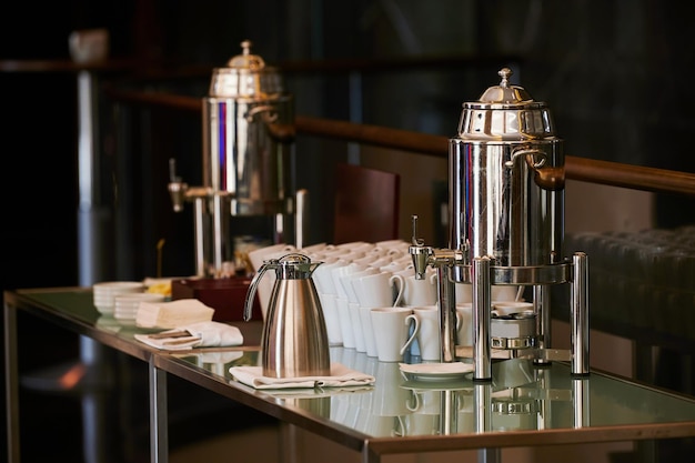 Serviço de café para uma pausa na recepção da máquina de café do evento e chaleiras de água quente na mesa para visitantes do seminário