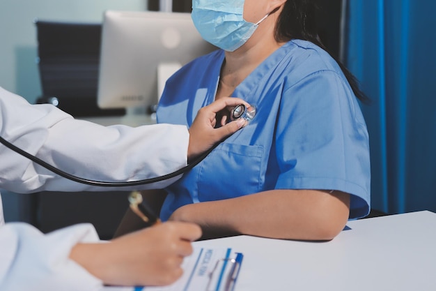 Serviço de enfermagem domiciliar e cuidados de saúde de cardiologia para idosos Fechar a jovem enfermeira hispânica verificando homem caucasiano maduro batimento cardíaco do paciente usando estetoscópio durante a visita