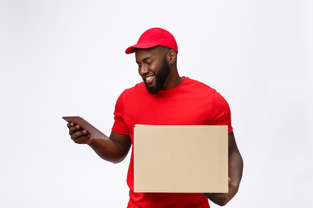 Serviço de entrega - retrato de feliz afro-americano entregador em pano vermelho, segurando um pacote de caixa.