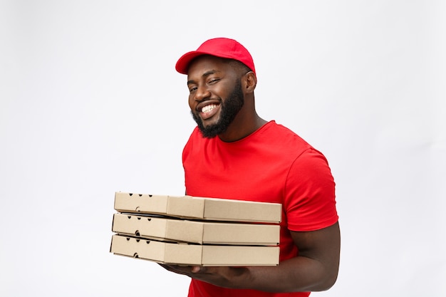 Serviço de entrega - retrato de um homem bonito afro-americano entregador de pizza.