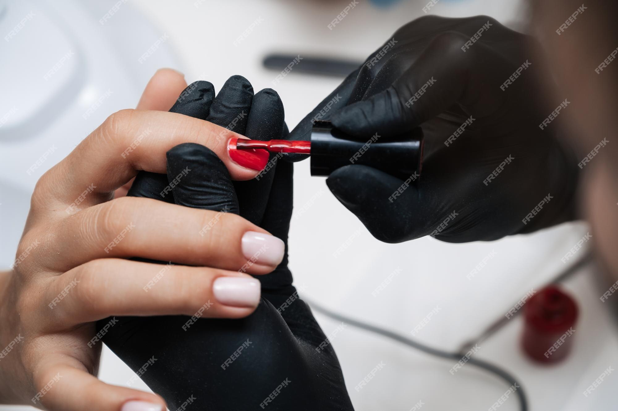 Esteticista aplicando verniz vermelho para unhas de mulher . fotos, imagens  de © Denisfilm #200364000