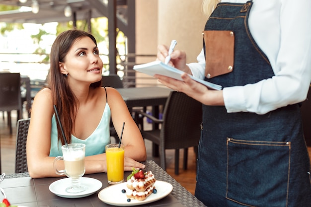 Servidor de garçonete, ajudando o cliente no café