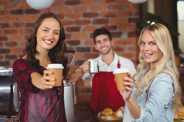 Servidor sorridente e dois clientes olhando para a câmera