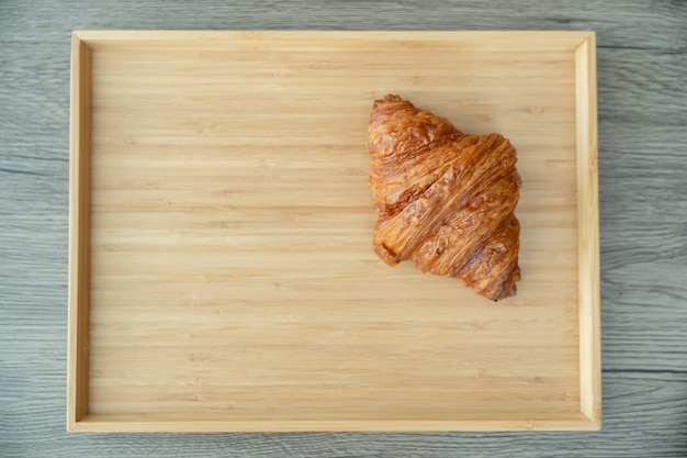 Serviert gebackene knusprige Croissants auf Holztablett.