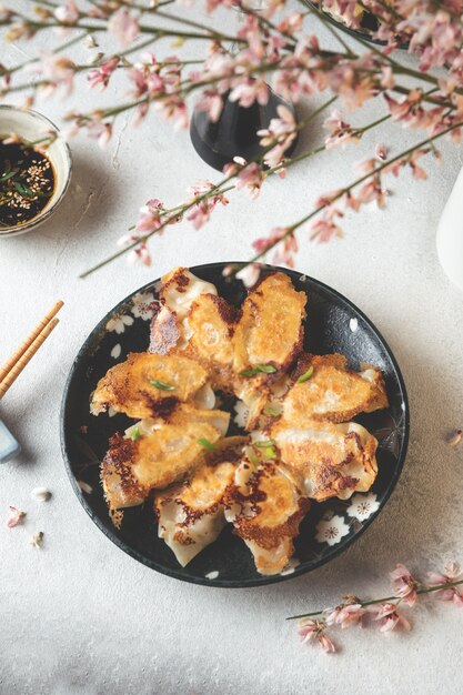 Serviertes Gericht aus gebratenen japanischen Gyoza-Knödeln mit Sojasauce auf leichtem Tisch