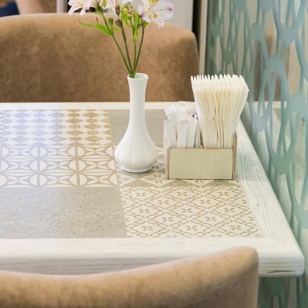 Foto servilletas de papel y flores sobre la mesa de un restaurante de moda, close-up