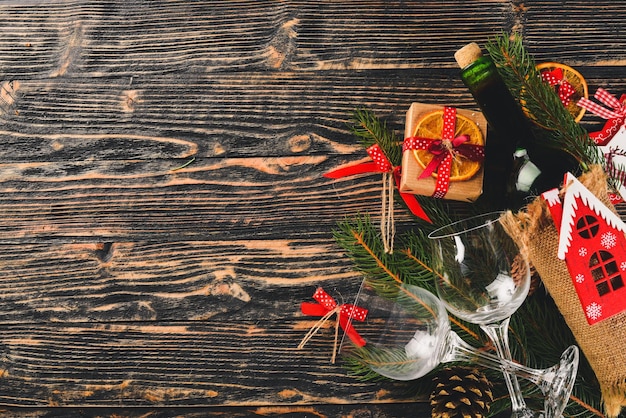 Servindo a mesa de Natal e uma garrafa de vinho Árvore de Natal de Ano Novo e enfeites de árvore de Natal Em um fundo de madeira Espaço livre para texto