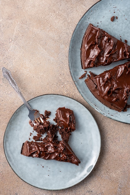 Servindo brownie de forma triangular com creme ganache. Vista superior, plana leigos, luz de fundo.