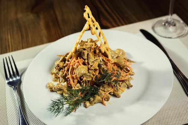 Servindo salada com cogumelos de frango e cenoura em um restaurante