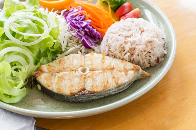 Servindo salada e peixe frito com arroz cozido para alimentos saudáveis.