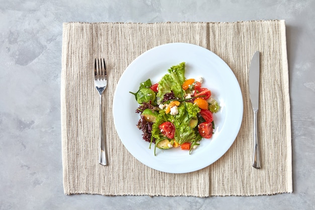 Servindo salada pronta com legumes frescos e queijo