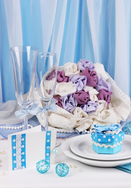 Servindo uma mesa de casamento fabulosa na cor azul sobre fundo de tecido azul e branco