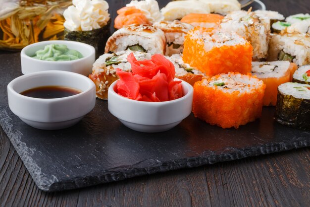 Serviu conjuntos de rolos de sushi com peixe, arroz, cream cheese e legumes
