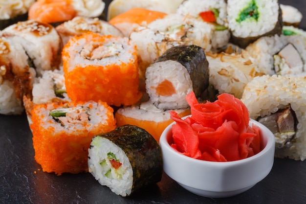 Serviu conjuntos de rolos de sushi com peixe, arroz, cream cheese e legumes