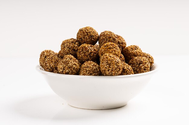 Foto sesame ladoo o ellu unda o til ladoo un dulce tradicional indio hecho de semillas de sésamo e imagen jaggeryisolated con fondo blanco