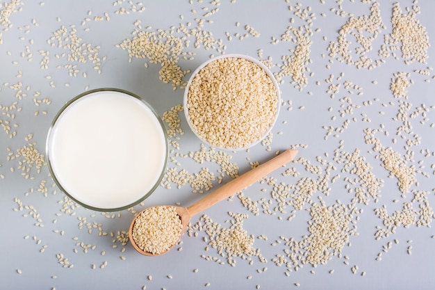 Sesammilch in einem Glas und Samen in einer Schüssel auf dem Tisch Dairy Alternative Draufsicht