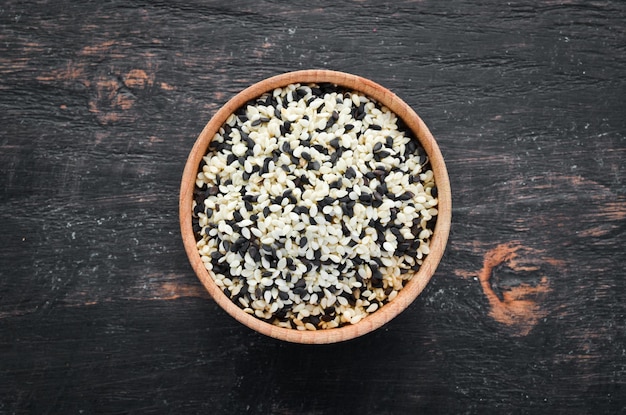 Sésamo Conjunto de semillas de sésamo en blanco y negro Sobre un fondo negro Vista superior Espacio de copia libre
