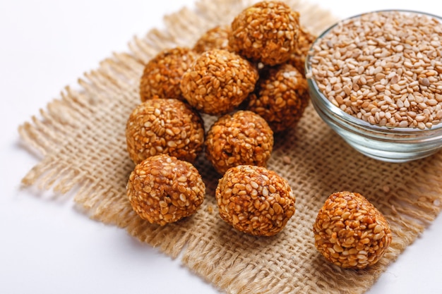 Foto sésamo dulce laddu y semillas de sésamo en un recipiente de vidrio