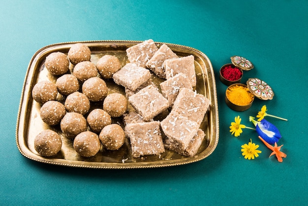 Sésamo o ril gul o Tilgul laddu con haldi kumkum con flores para Makar Sankranti Festival, enfoque selectivo