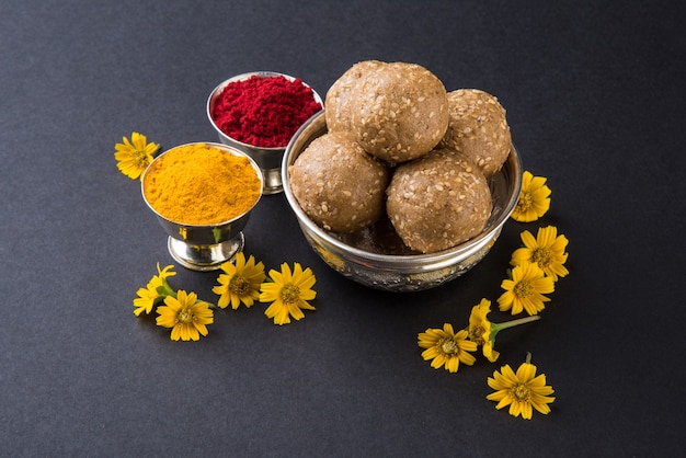 Sésamo o Tilgul laddu con haldi kumkum con flores para Makar Sankranti Festival, enfoque selectivo