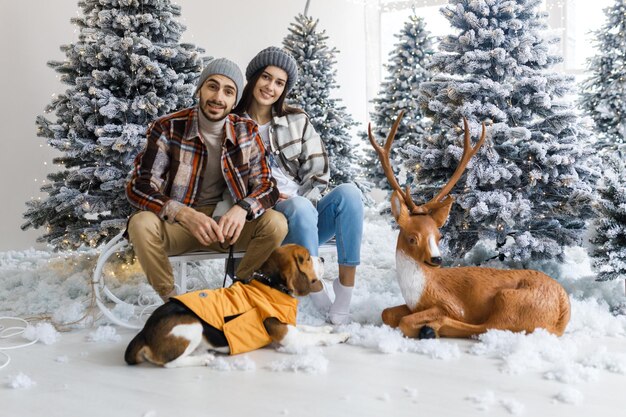 Sesión de fotos en el estudio de una pareja joven Pareja con su perro Un chico con una chica está celebrando la historia de amor de Navidad Año Nuevo