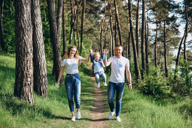 Sesión de fotos familiares en la calle en un cálido día soleado en un bosque de coníferas en primavera