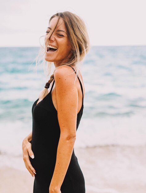 Sesión de fotos de una mujer embarazada caminando por la playa