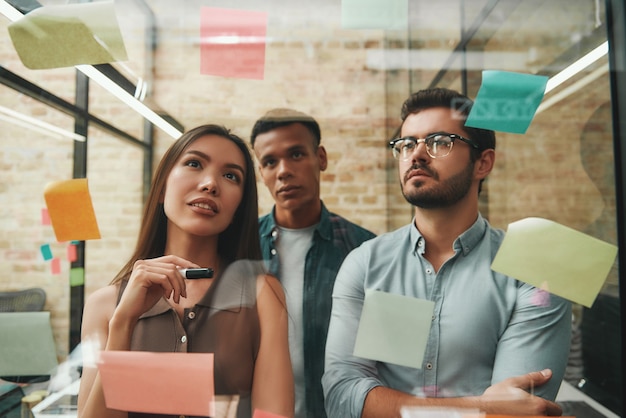 Sesión de lluvia de ideas colegas masculinos y femeninos alegres que planifican el proceso de trabajo y utilizan