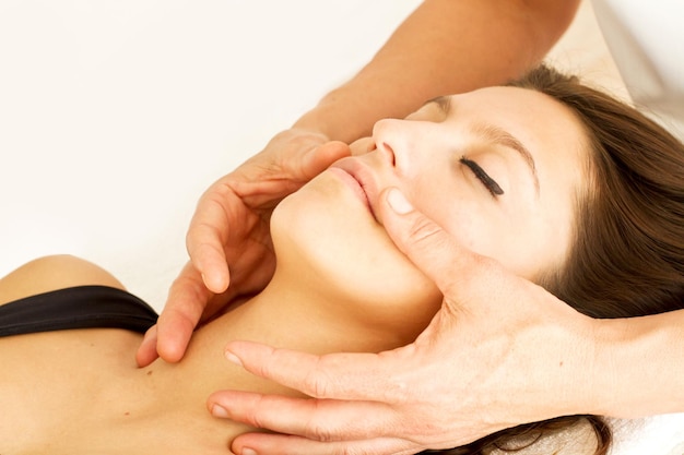 Sesión de masajes relajantes a una mujer en la cara y la cabeza