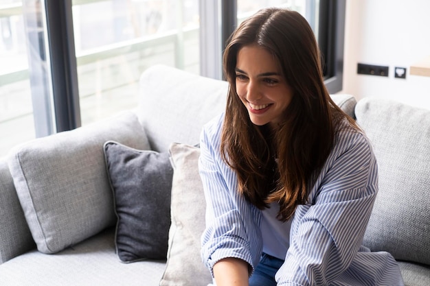 Sesión de terapia psicológica femenina con una chica sentada en el sofá sonriendo alegremente