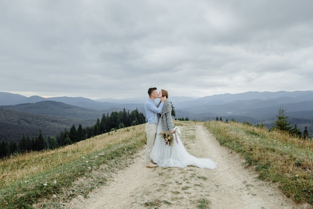 Sessão de fotos da noiva e do noivo nas montanhas. foto de casamento estilo boho.