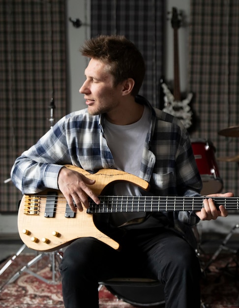 Sessão de guitarra casual em um estúdio de música em casa durante o dia pessoa masculina tocando guitarra e cantando canção
